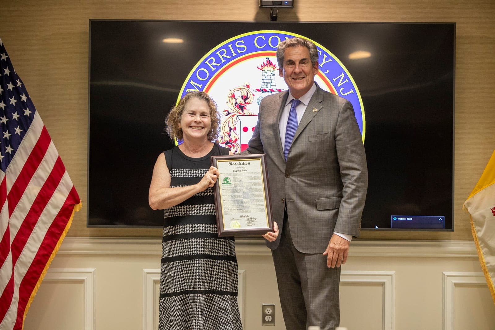 Commissioner Director Stephen H. Shaw presents a resolution of honor to Debbie Leon, retiring executive director of Literacy Volunteers of Morris County.